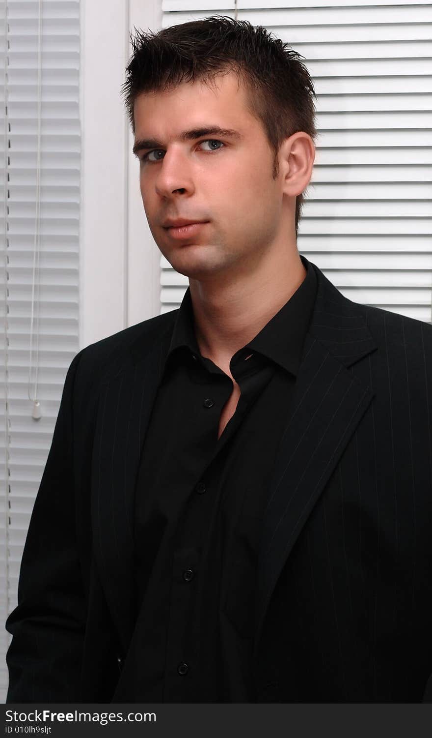 Portrait of a young businessman dressed in black suit