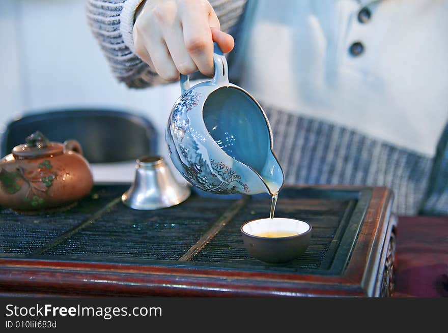 Man pouring green tea to traditional japanese cups