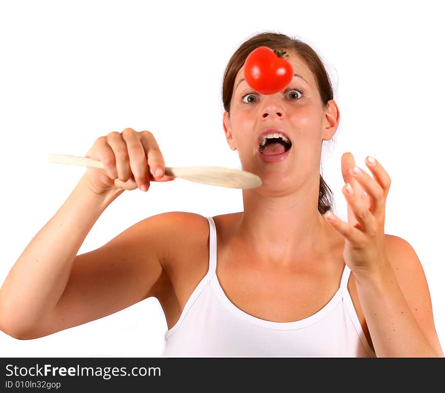 A young happy woman with a tomato and a spoon. Can be used as a cooking / diet shot. A young happy woman with a tomato and a spoon. Can be used as a cooking / diet shot.