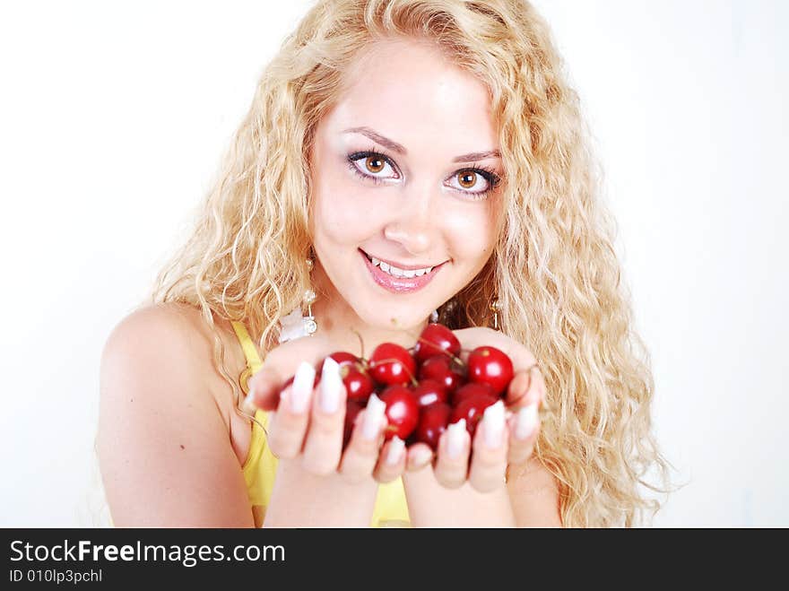 Beauty young woman with opened eyes and red cherry in mouth