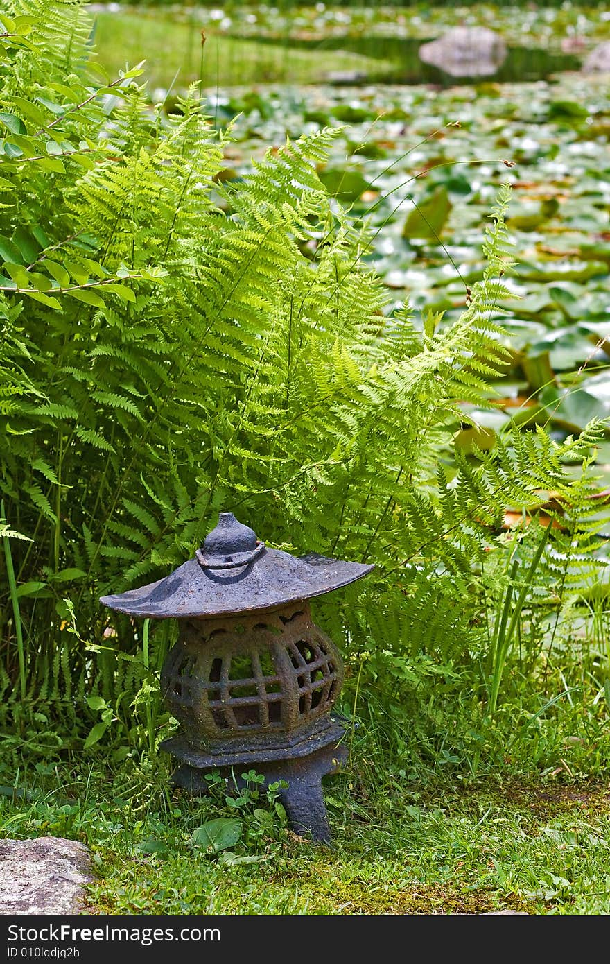 Japanese lantern at lily pond in stroll garden.