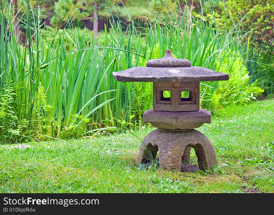 Japanese lantern in a stroll garden with reeds.