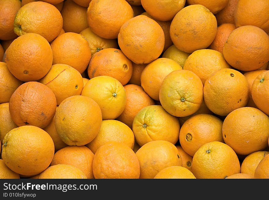 Fresh fruit market shot showing oranges filling the frame of the image, suitable as a background