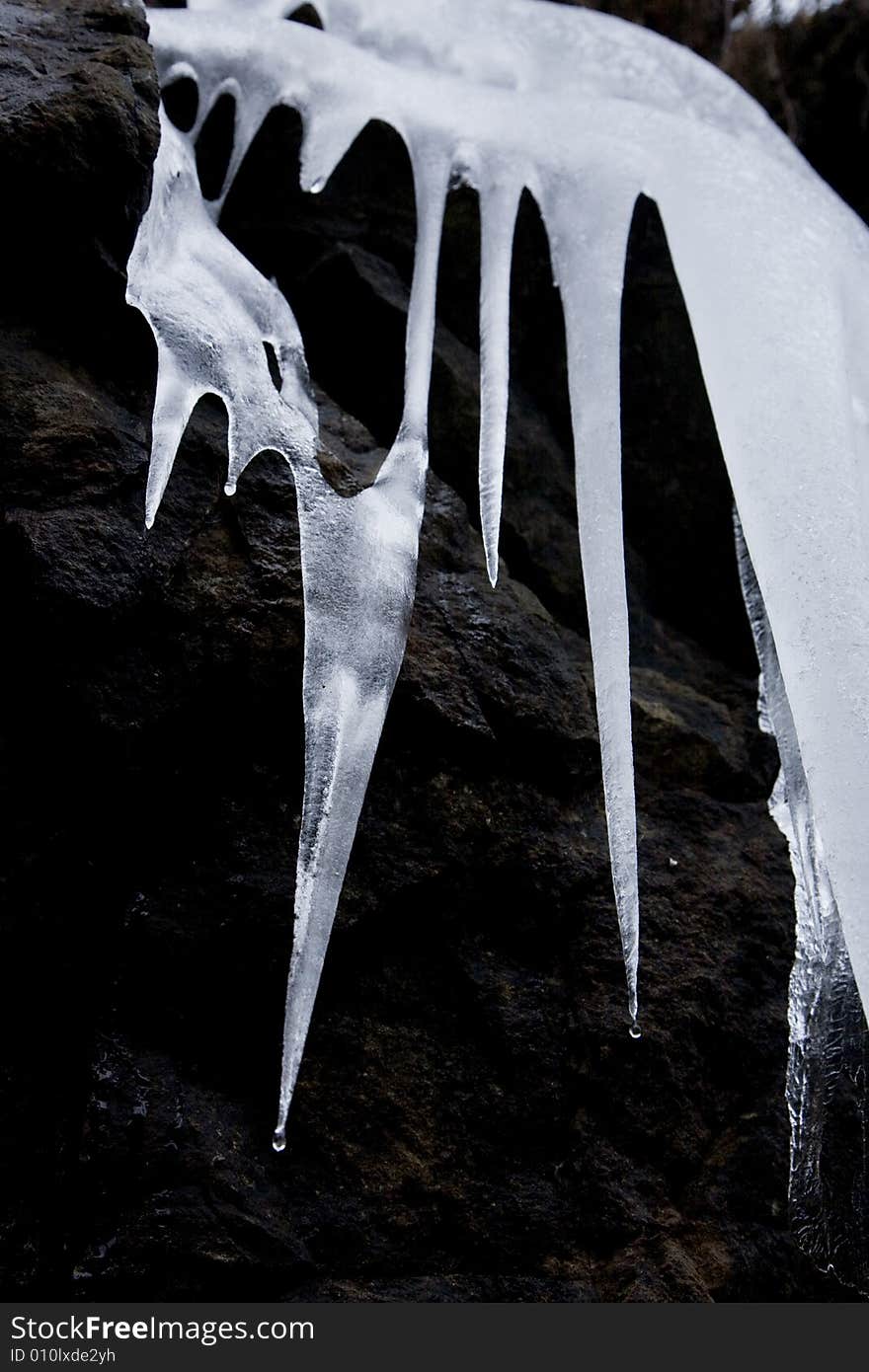 Some icicles dripping on a stone