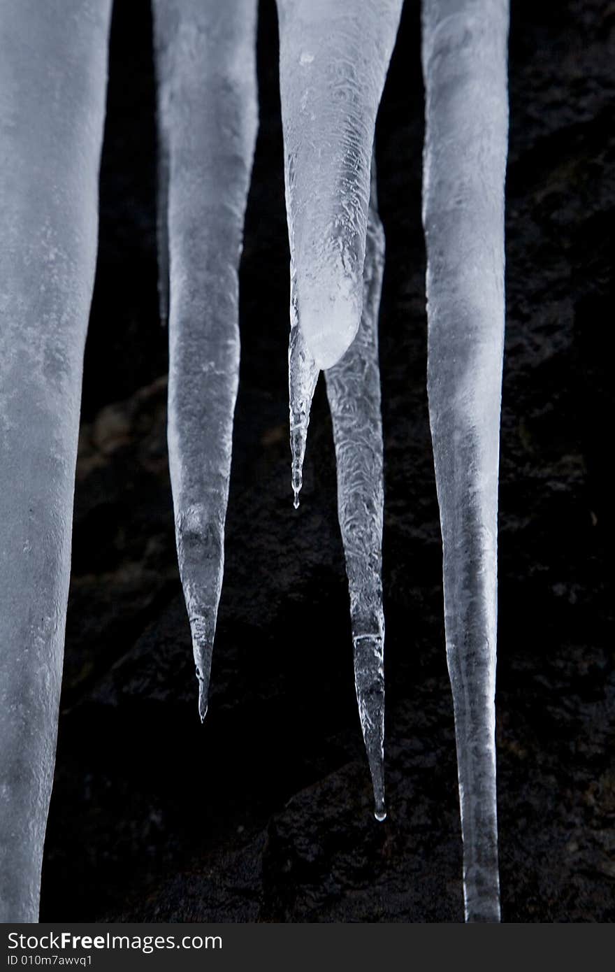 Some icicles dripping on a stone