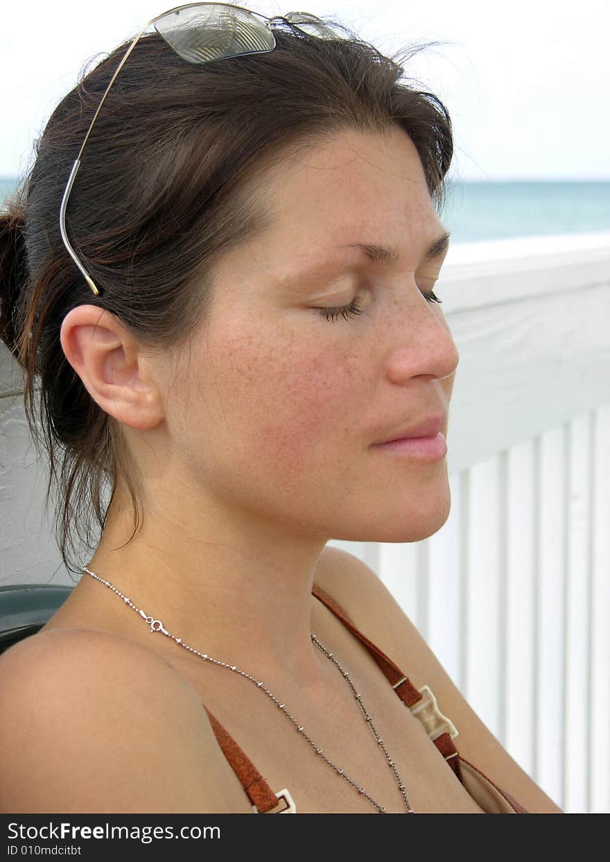 The portrait of the girl with closed eyes on Sandyport beach in Nassau town, The Bahamas.