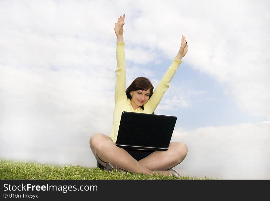 Girl with laptop sitting on the grass