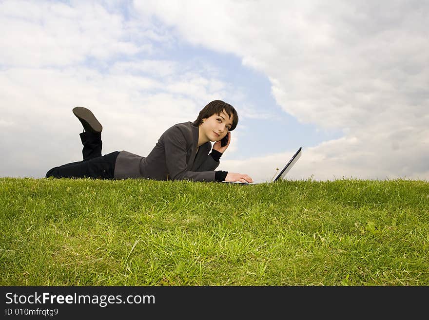 Girl with laptop sitting on the grass