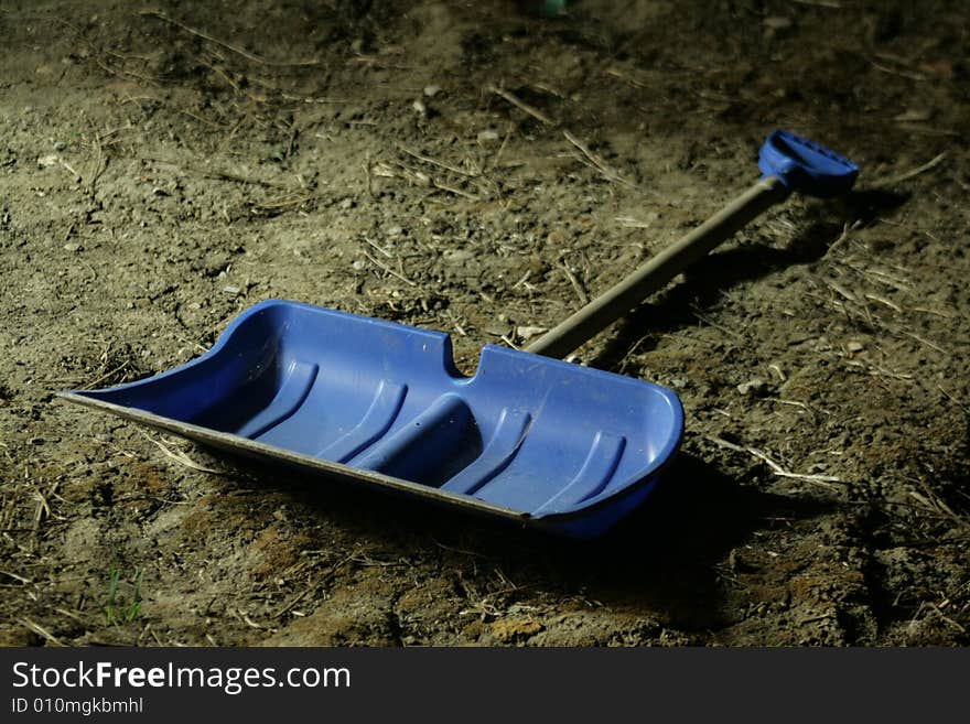 Blue plastic shovel whit wooden barrel.