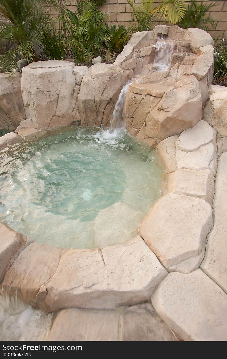 Tropical Custom Pool Jacuzzi with rocks and waterfalls.