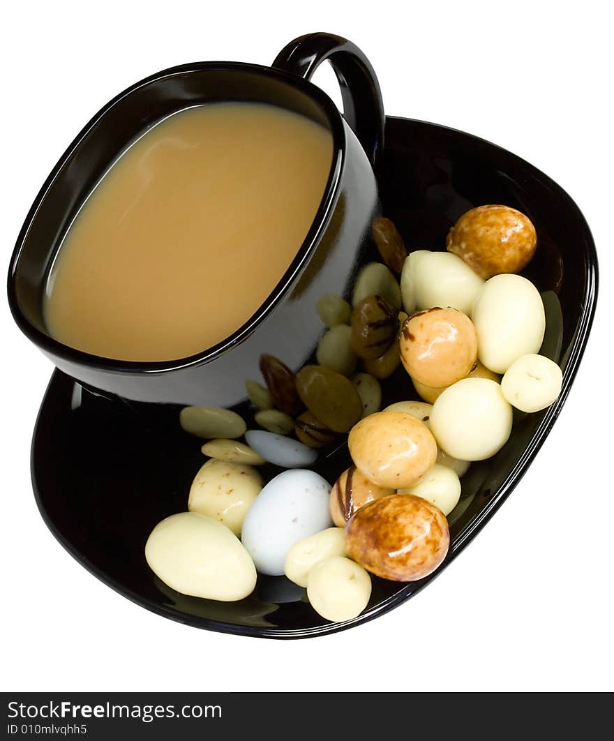 Cup of coffee with milk and candies