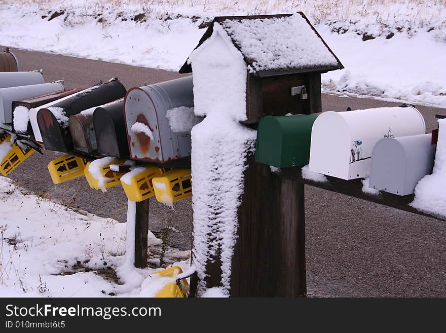 A row of rural mailboxes covered in snow. A row of rural mailboxes covered in snow