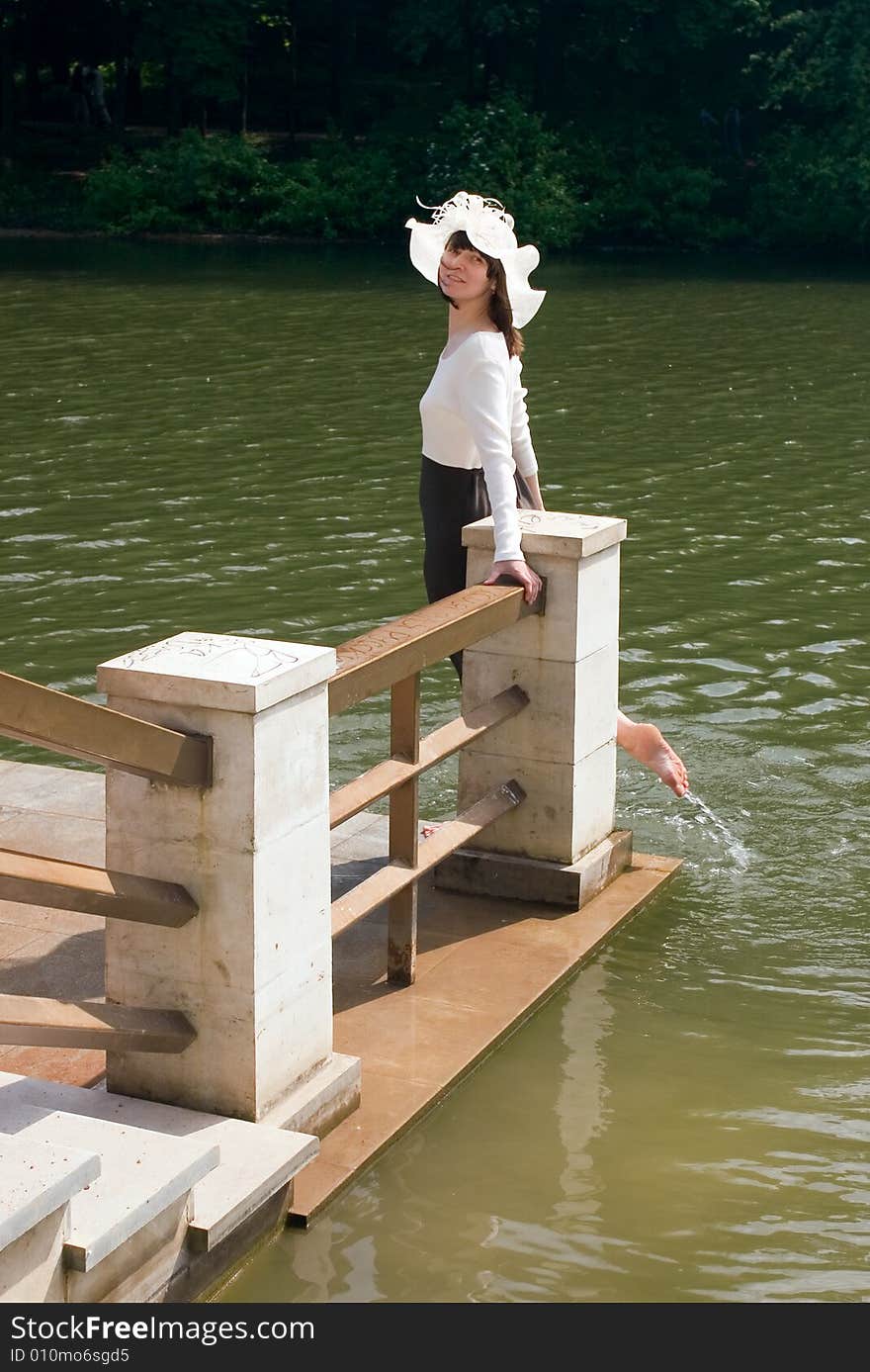 Girl in a hat on coast of the river. Girl in a hat on coast of the river