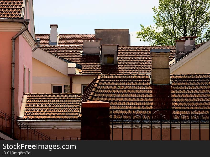 Tile roofs of the old houses with chimneies