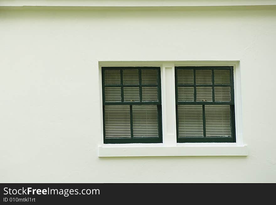 Close up of a window on the side of a white stucco building. Close up of a window on the side of a white stucco building.