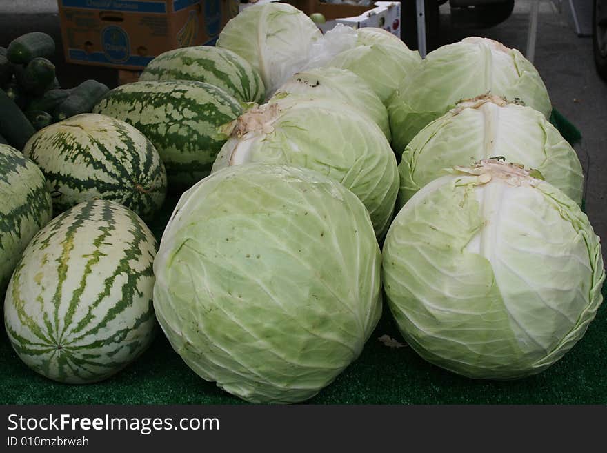 Cabbage and melons at a farmer's market.