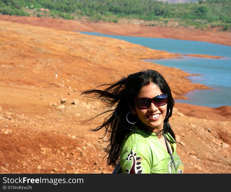 A beautiful Indian babe posing with her long hair flying in the wind, at a lakeside. A beautiful Indian babe posing with her long hair flying in the wind, at a lakeside