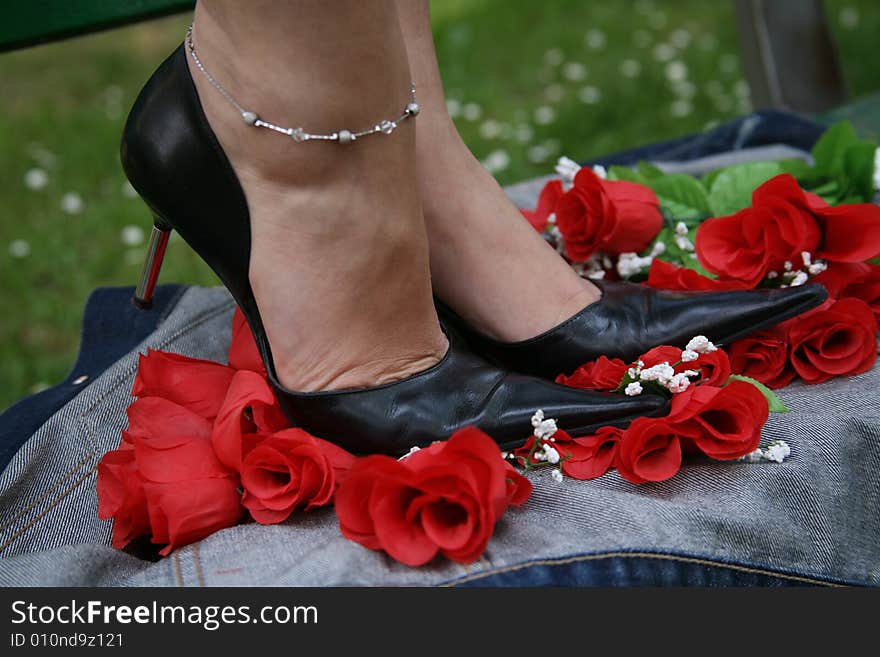 Female feet dressed in fashion shoes and socks, crushing roses. Female feet dressed in fashion shoes and socks, crushing roses.