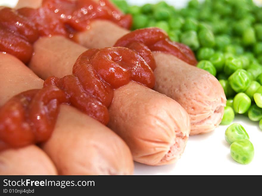 Sausage with green peas on a plate