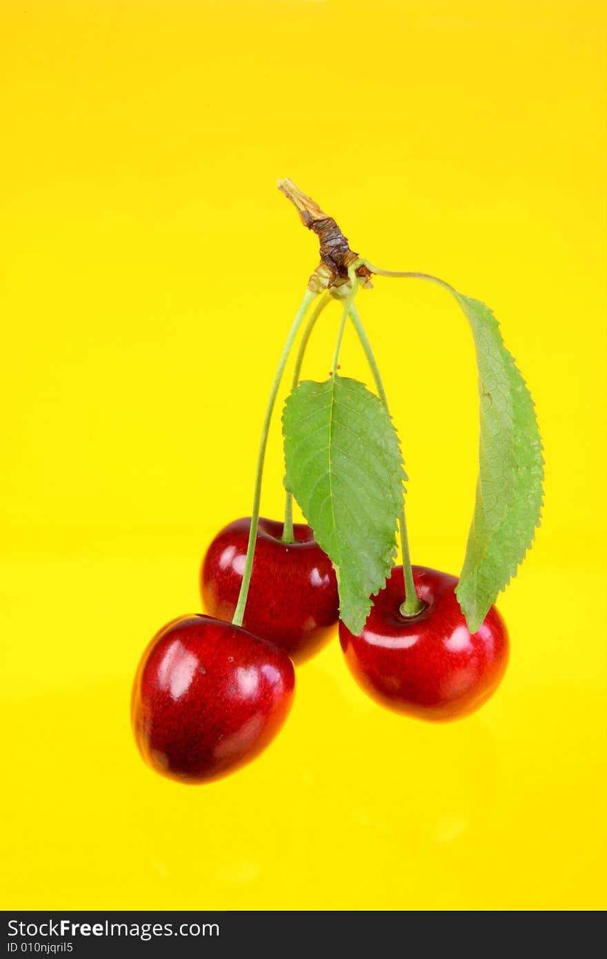 Three cherries with leafs.