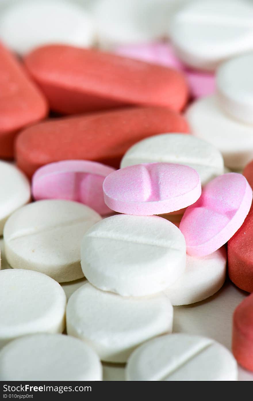 Close up of pink, red and white pills. Close up of pink, red and white pills