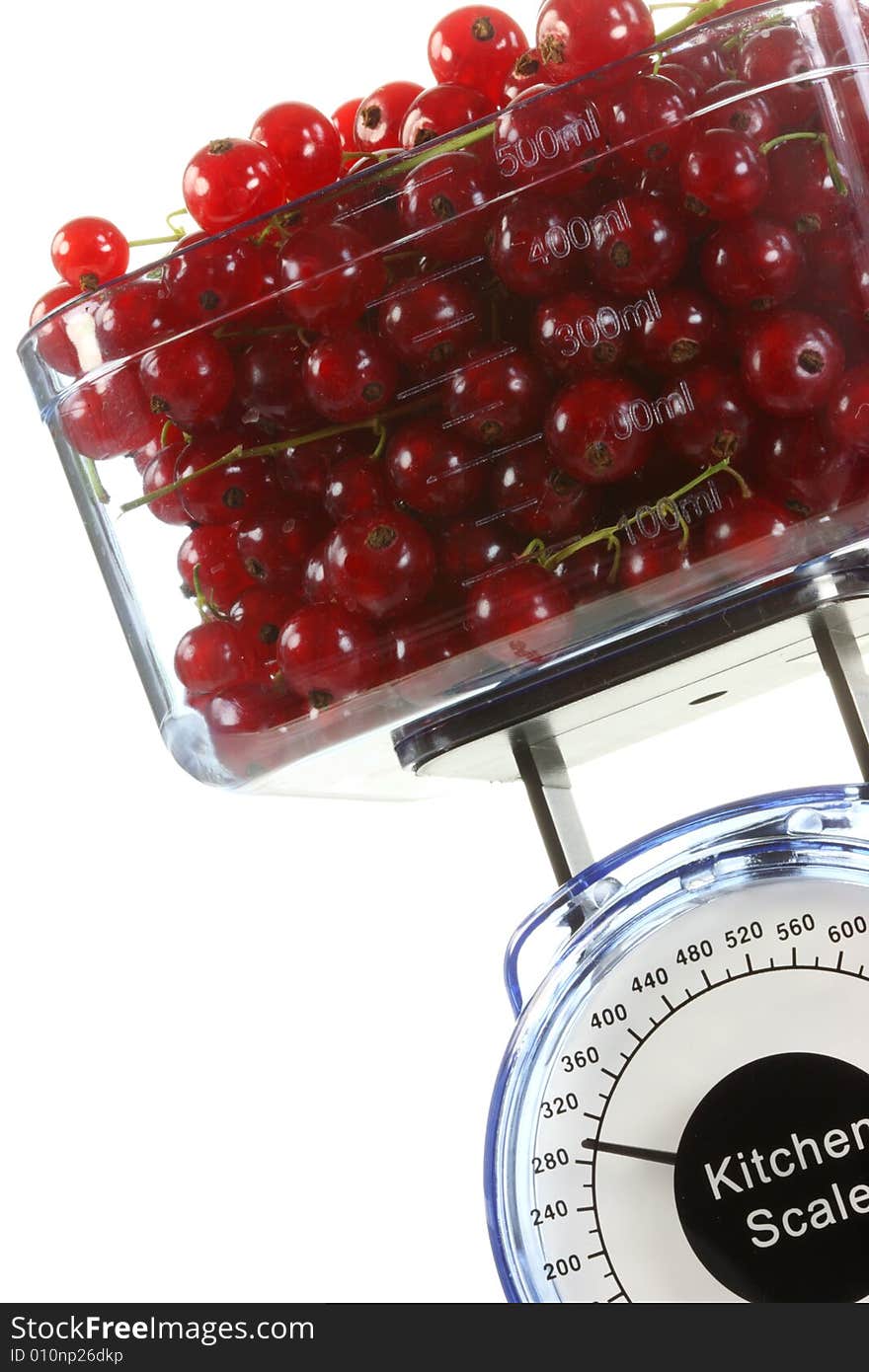 Kitchen scales and red currants on a white background. Kitchen scales and red currants on a white background.