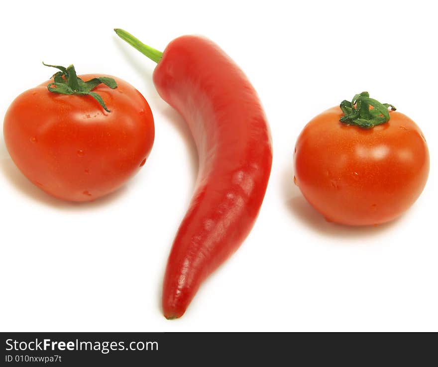 Two fresh tomatoes and a ripe chili pepper isolated on white background. Two fresh tomatoes and a ripe chili pepper isolated on white background