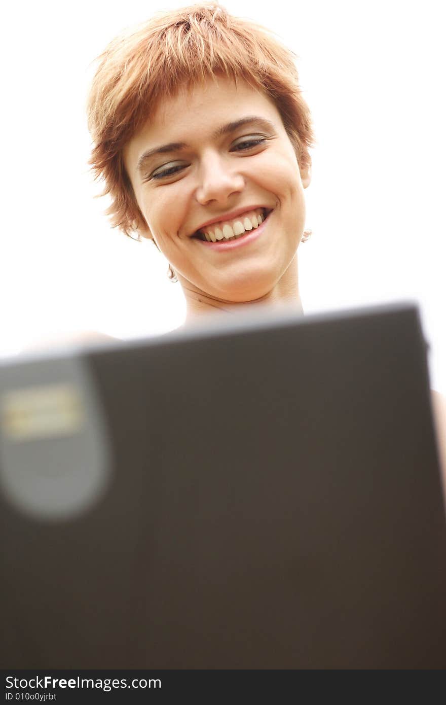 Young woman smiles and working on laptop