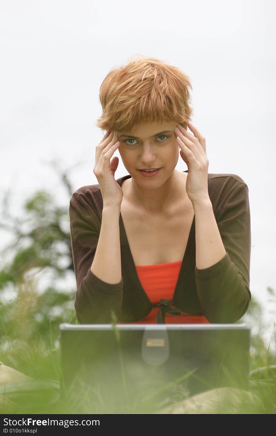 Young girl working on laptop and thinking