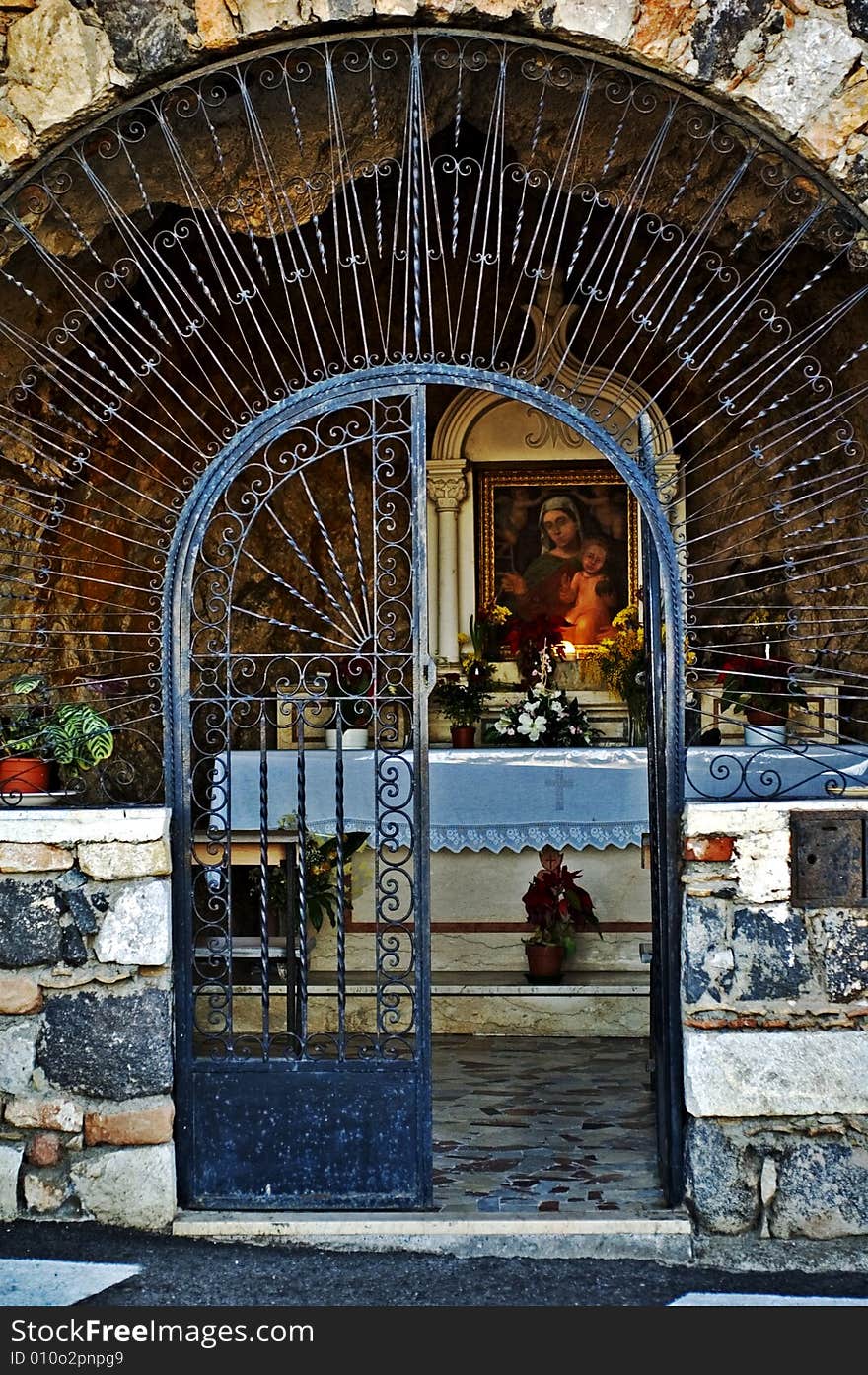 Gate opening in front of an old Italian chapel