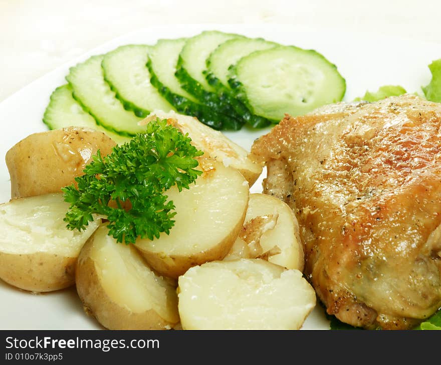 Roasted chicken with potatoes and cucumbers. Roasted chicken with potatoes and cucumbers