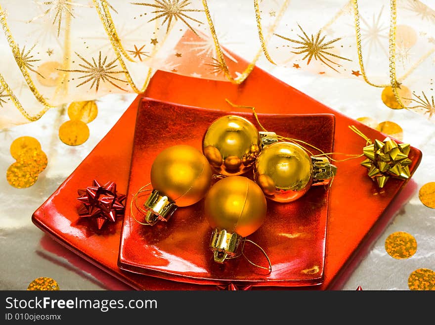 Golden Christmas balls on red plate