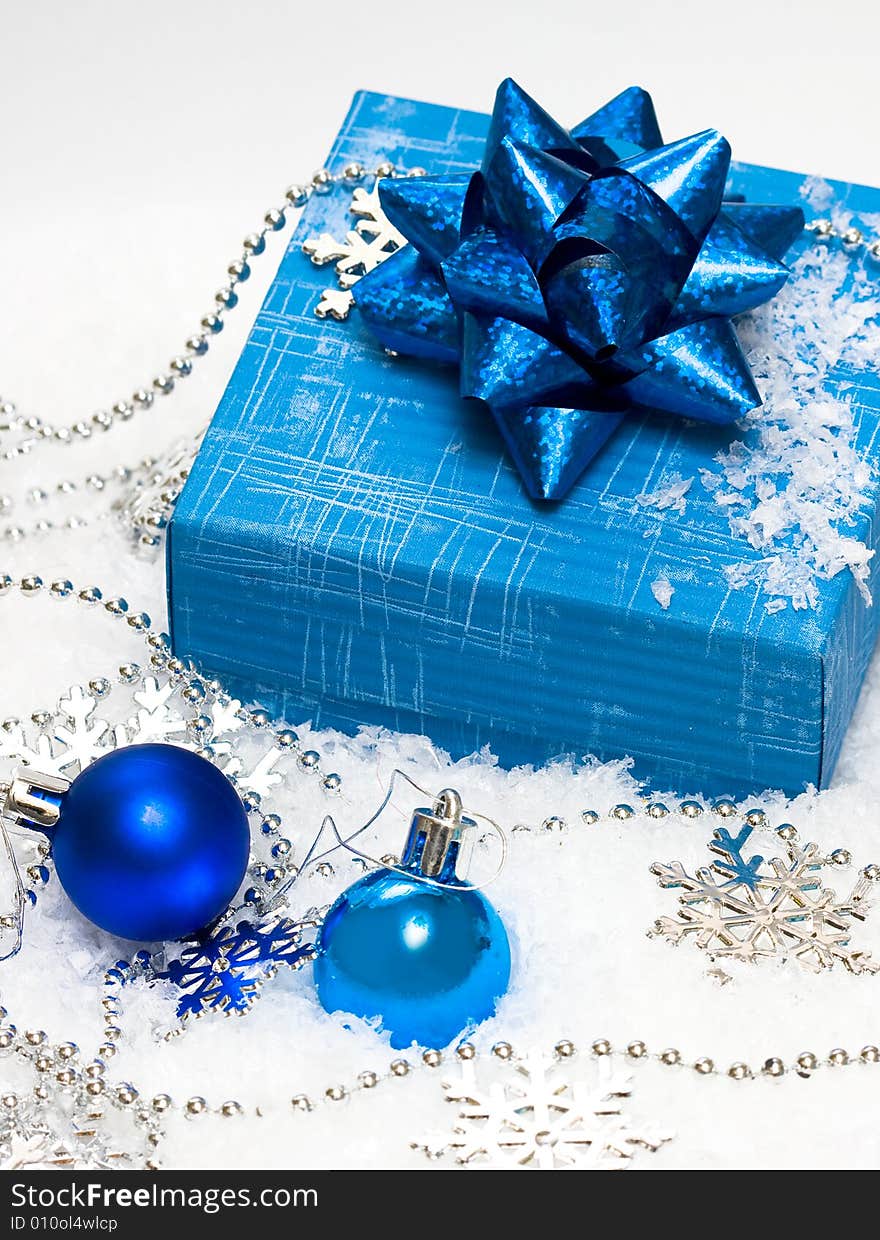 Festive balls with gift box on snow