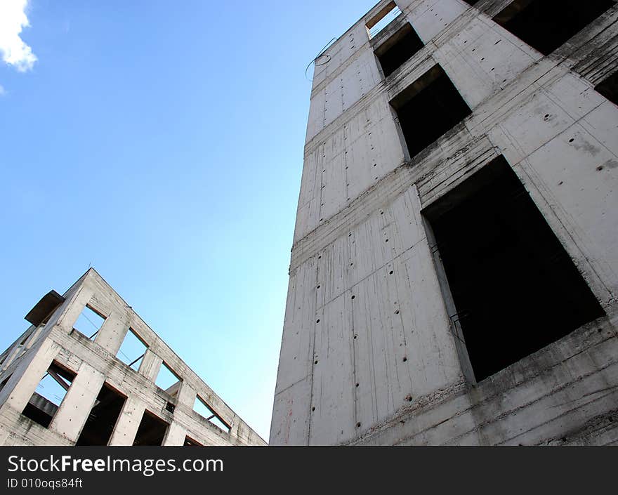 Two unfinished gray buildings with sky. Two unfinished gray buildings with sky