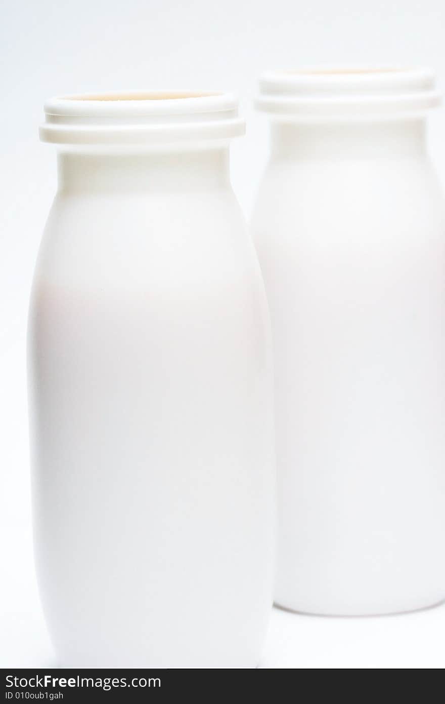 Two jars with milk over white