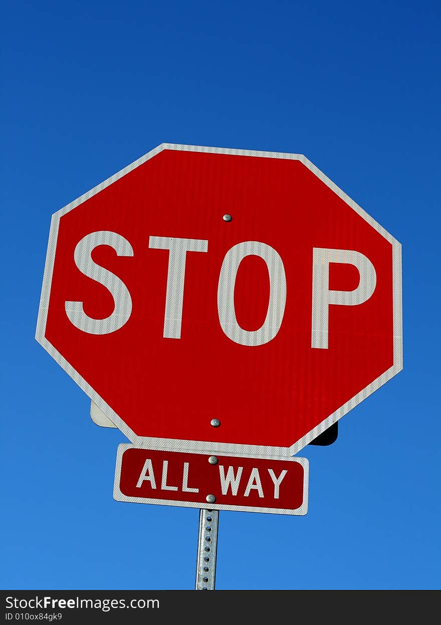 A stop sign in front of a blue sky.