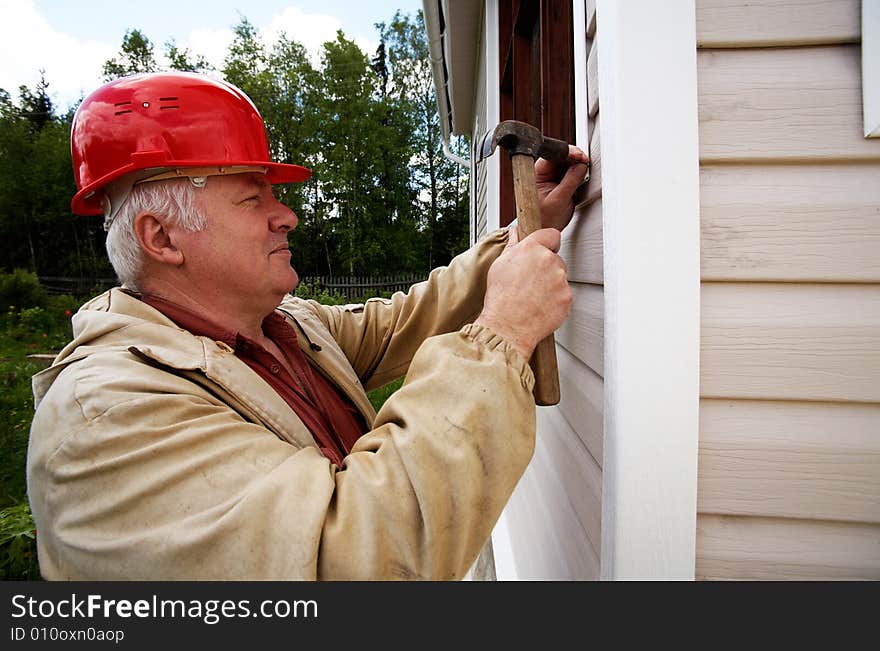 Smiling mature master with hammer