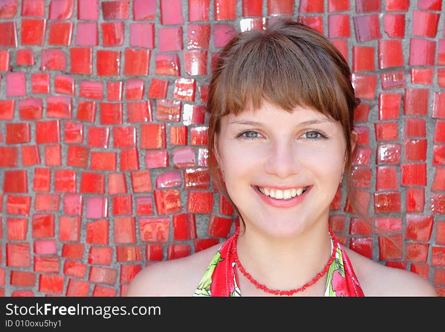 Beautiful woman posing for the camera  with emotions against red wall