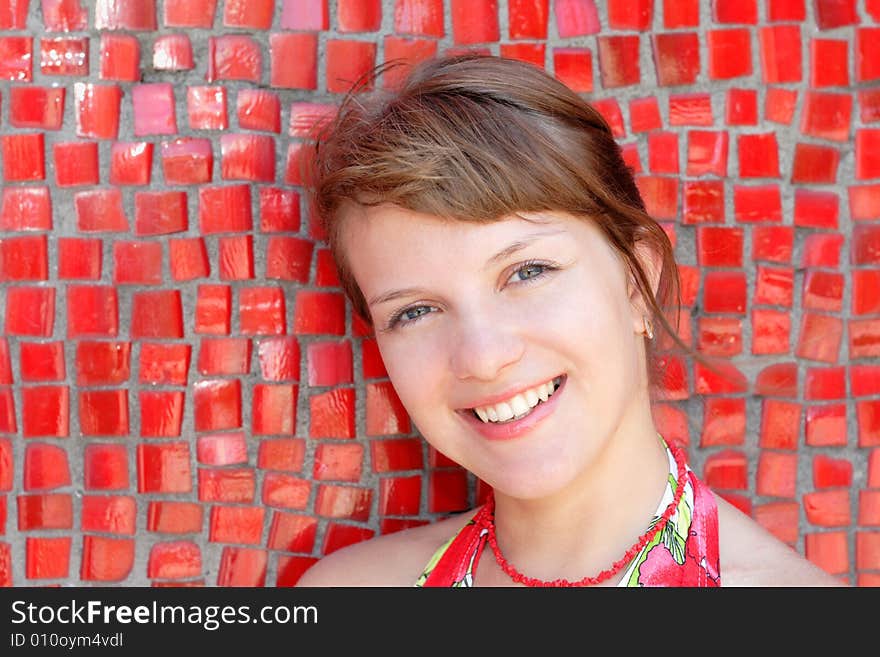 Beautiful woman posing for the camera  with emotions against red wall