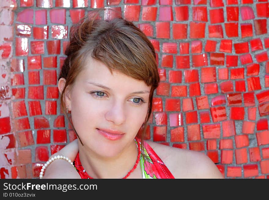 Beautiful woman posing for the camera  with emotions against red wall