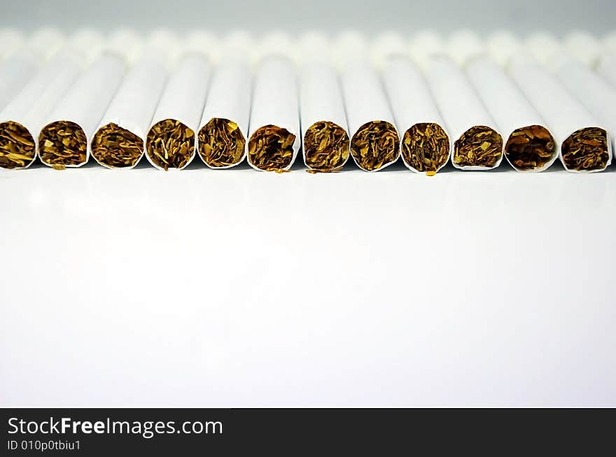 Cigarettes laying in line on a white background. Cigarettes laying in line on a white background