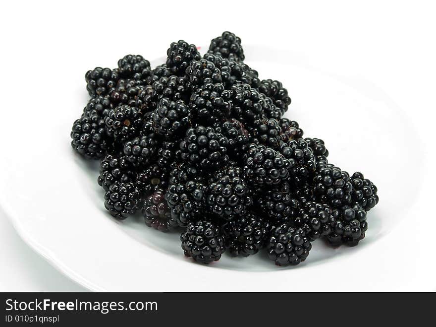 Blackberry on the plate , isolated on white