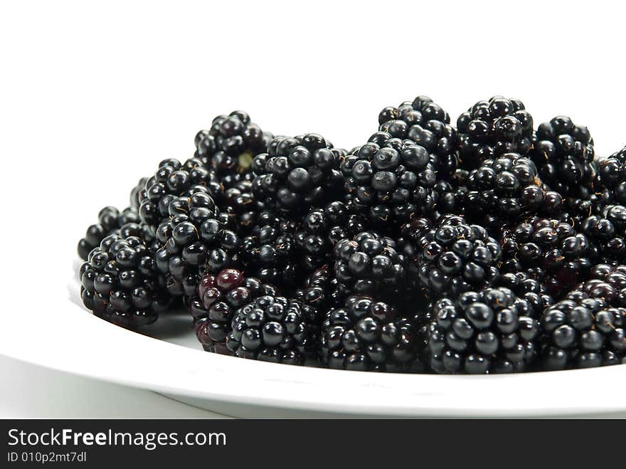 Blackberry on the plate , isolated on white