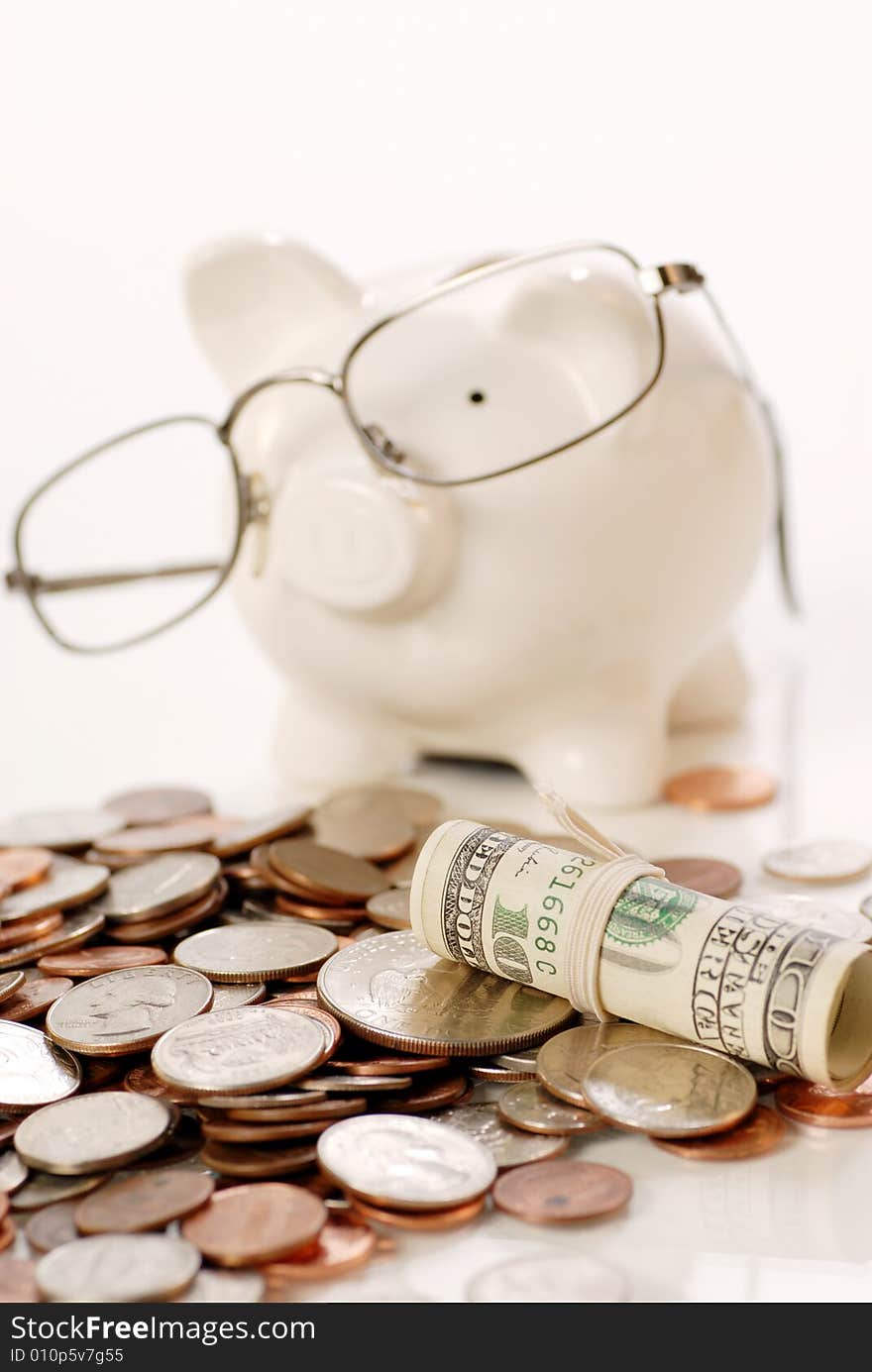 US coins and currency and blur piggy bank wearing glass background