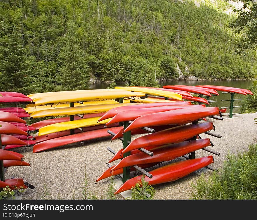 A bunch of yellow and red stacked kayaks