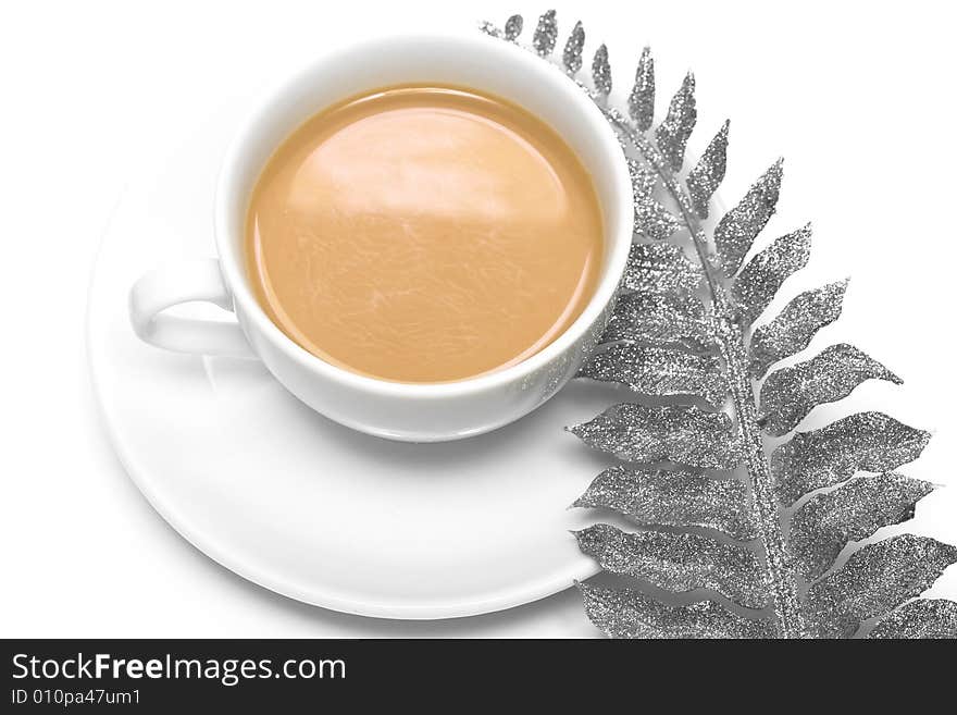 White cup of coffee with silver leaf