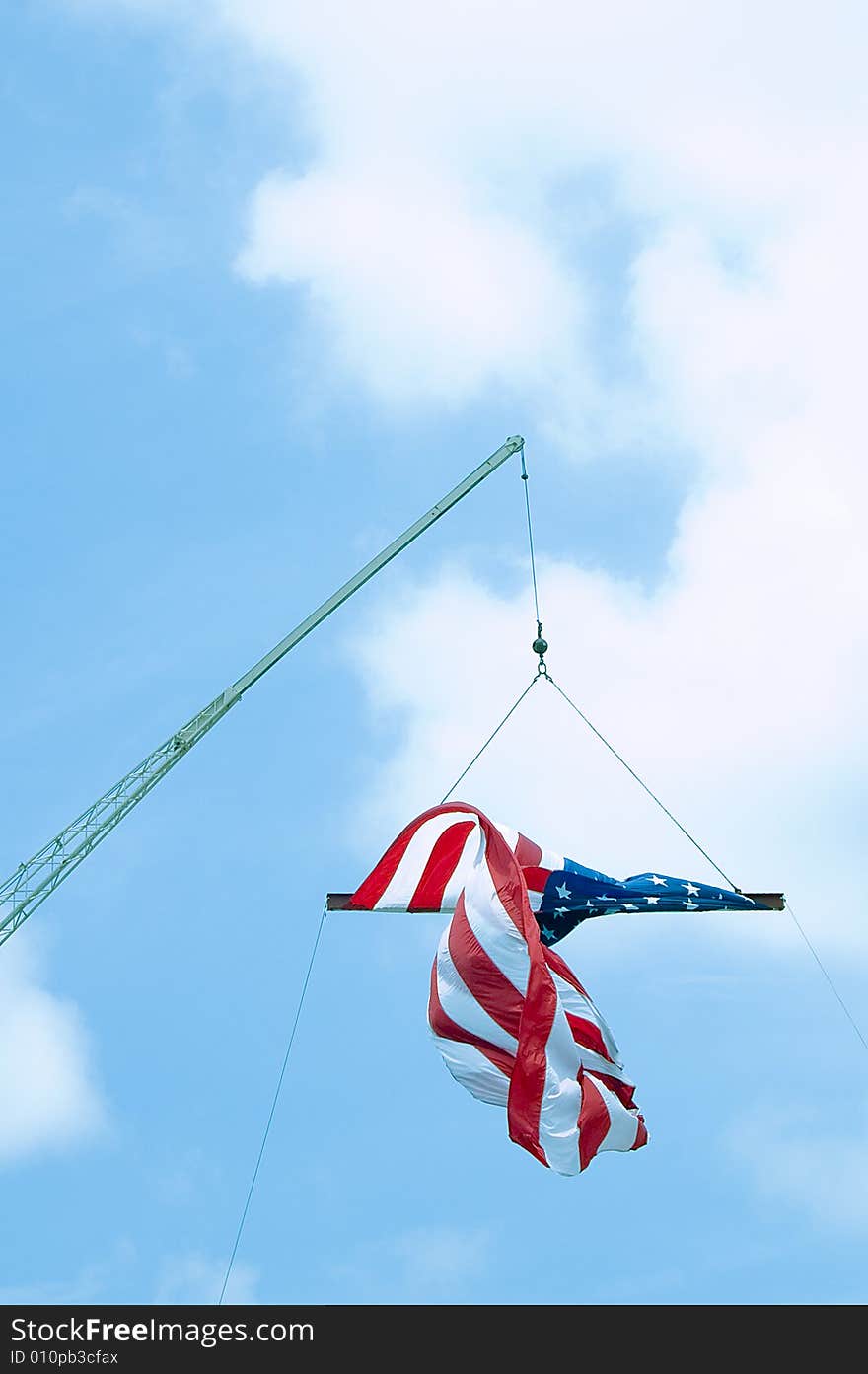 A crane suspending an American flag on the fourth of July.