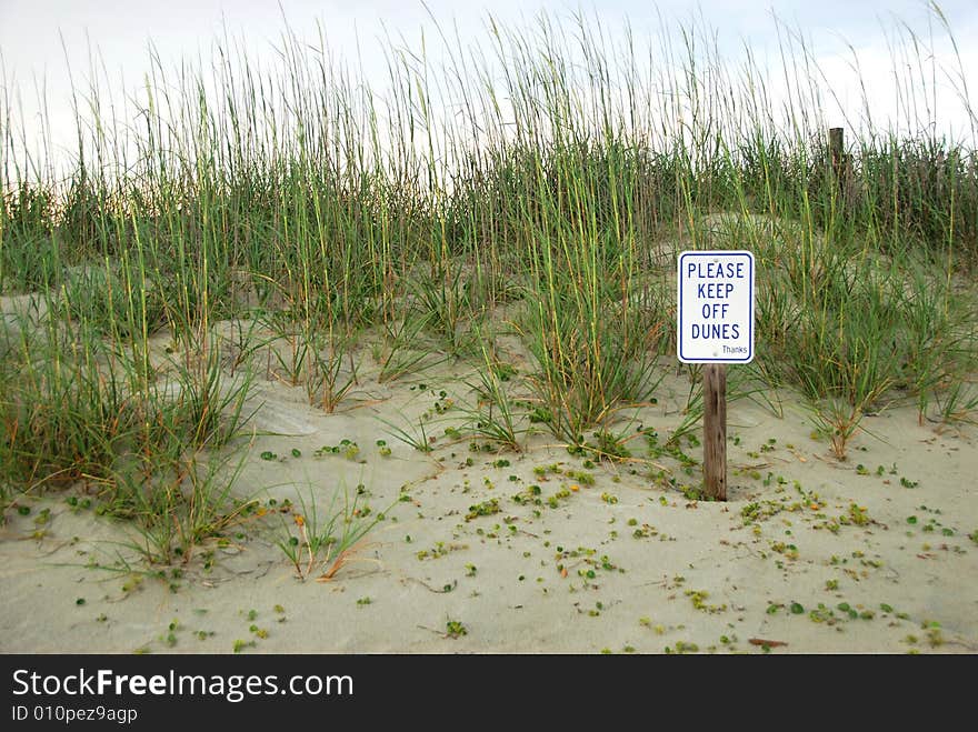 A prohibitory sign on a sand dune. A prohibitory sign on a sand dune.