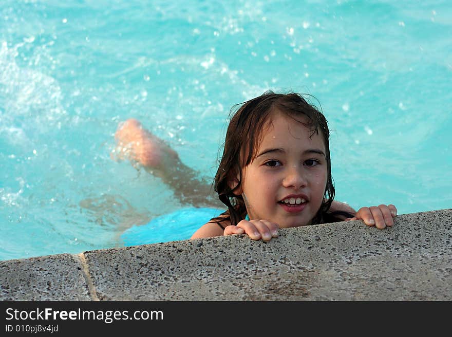 Girl holding onto edge of pool