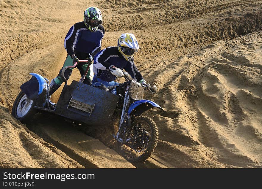 Two motorcyclists aspire to finish on sandy road. Two motorcyclists aspire to finish on sandy road